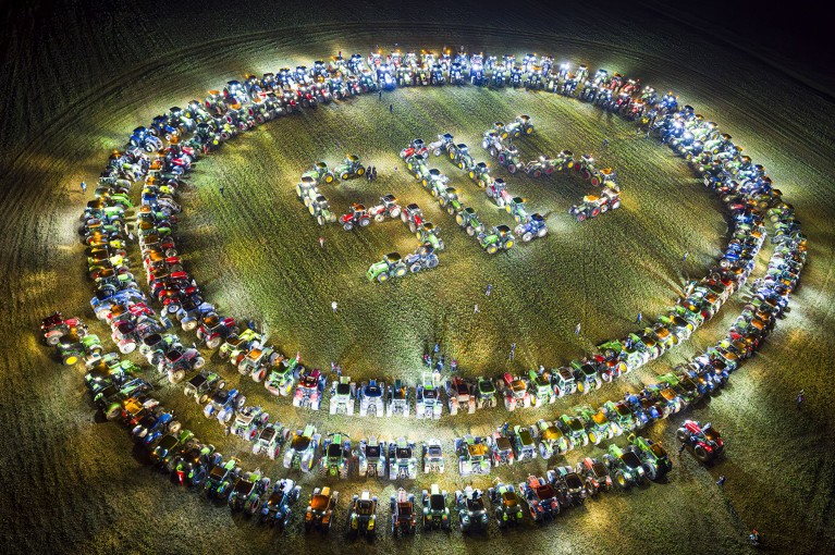 Farmers form a giant 'SOS' distress signal with their tractors at night as replicated in various locations across Switzerland.