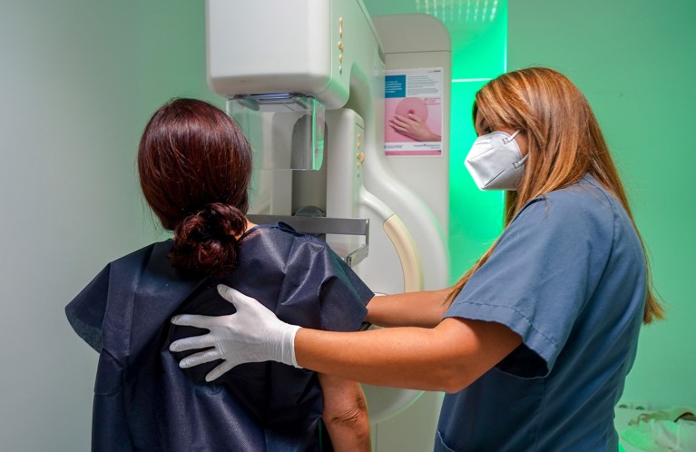 A woman is assisted by a nurse in getting a mammogram at a hospital in Seville, Andalusia.