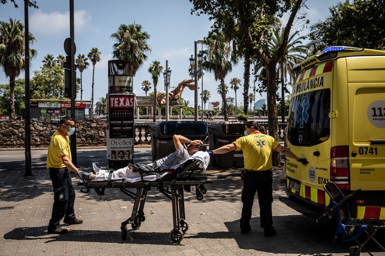 I paramedici aiutano un paziente in un'ambulanza durante un'ondata di calore a Barcellona, ​​in Spagna.