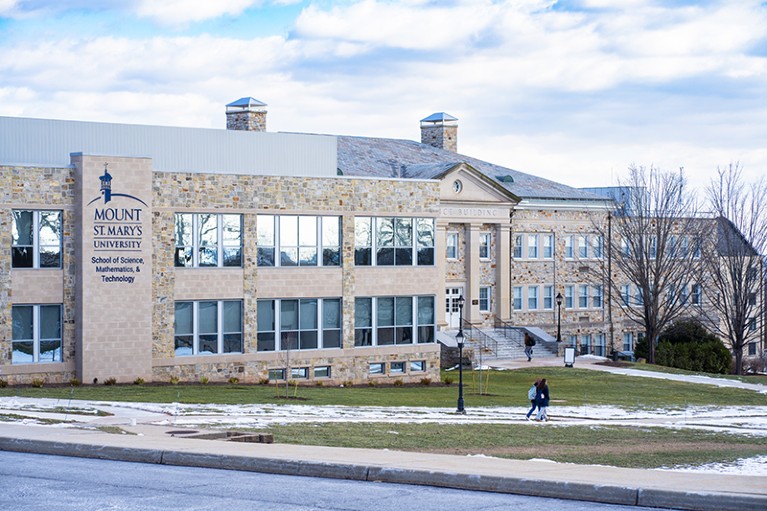 A large brick building with a green lawn in front of it