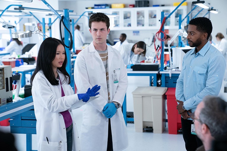 Camryn Mi-young Kim and Dylan Minnette stand in a lab in the TV series "The Dropout"