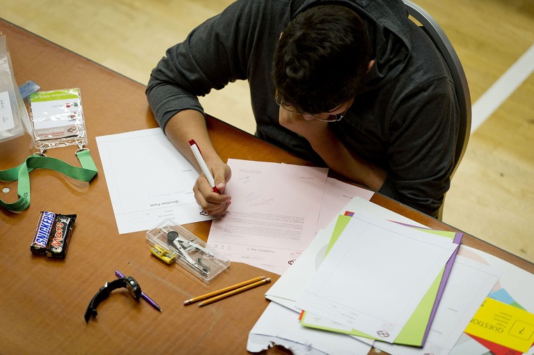 An aerial view of a competing student intensely studying problems on sheets of paper during the International Mathematical Olympiad Amsterdam 2011.