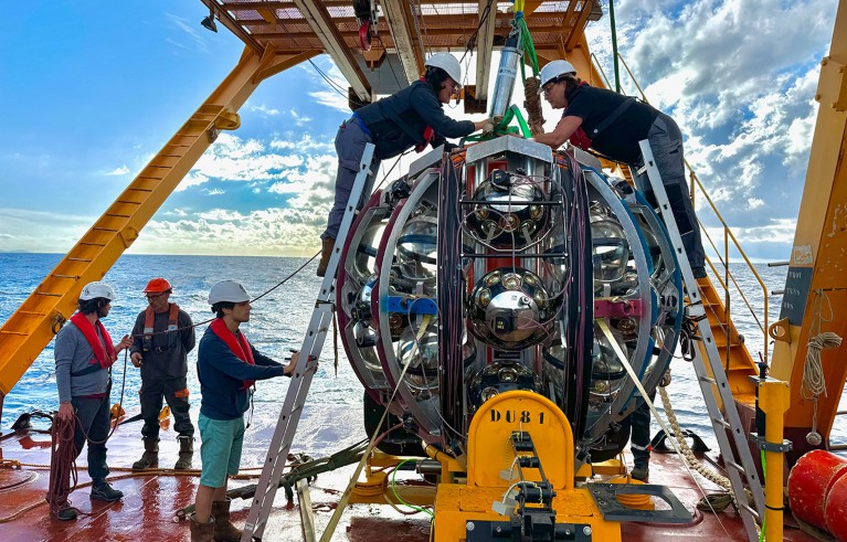 Crew members make final inspections of a KM3NeT Detection Unit and Launcher vehicle module before deployed from the ship's deck.