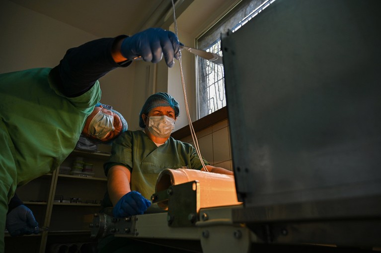 Two researchers wearing masks work on producing medicinal hydrogel dressings.