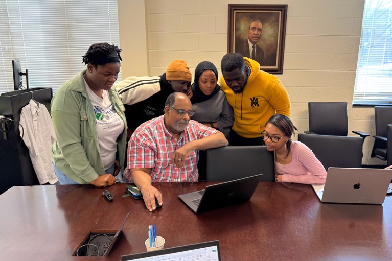 Joseph L. Graves and his students gathered around a laptop in a classroom