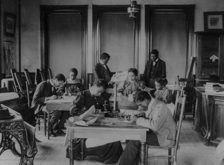 Black and white historical photograph of African American students working at tables in a biology laboratory circa 1899