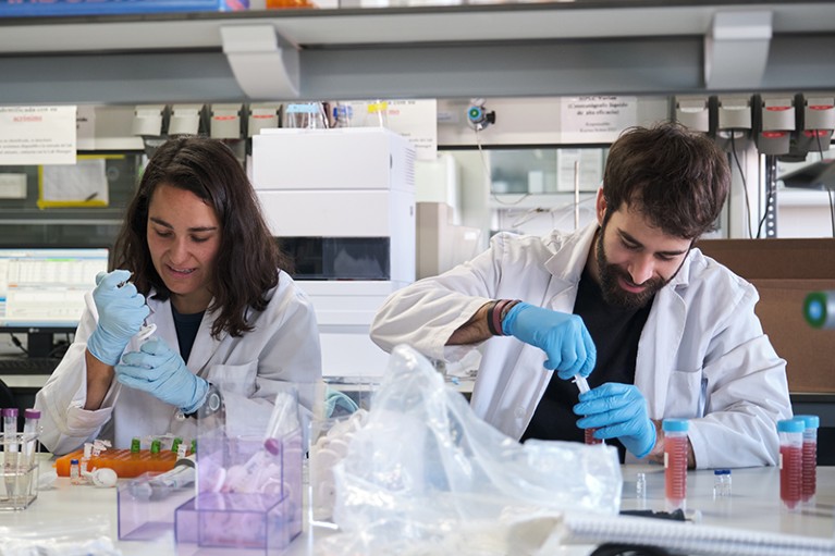 Two young PhD students in a laboratory.