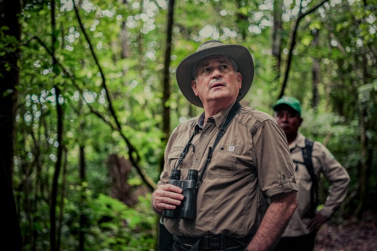 Juan Carlos Navarro holding binoculars in a forest in a national park in Panama