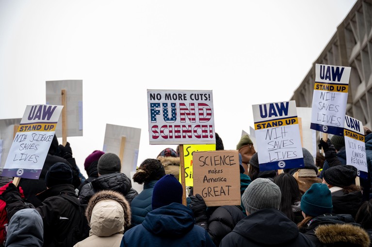 Scientists and their supporters protest with signs outside the U.S. Department of Health and Human Services.