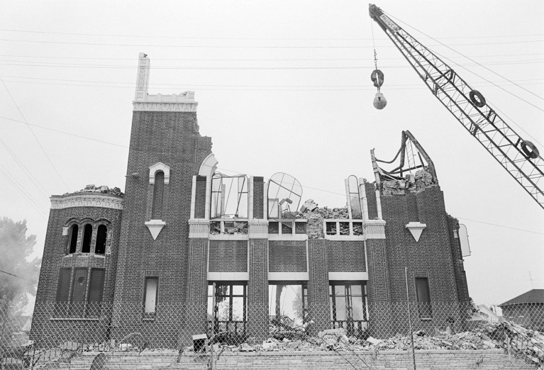 Demolished Building by a crane and wrecking ball on the right.