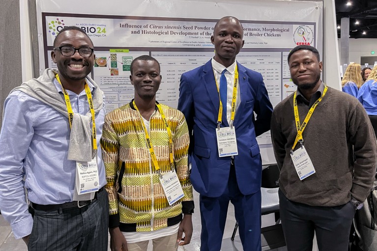 Rafiou Agoro poses in front of a conference poster with fellows Justin Adébayo Hounkpevi, Tchilabalo Parobali and Dzifa Ahiatrogah at the Cell Bio 24 conference