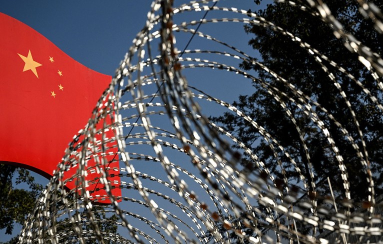 Barbed wire and a Chinese national flag.