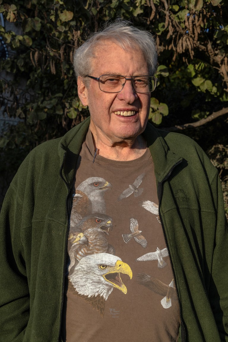 A portrait of Yossi Leshem wearing a shirt with photos of different types of birds