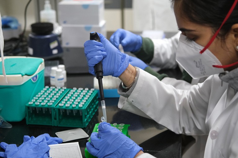 Un tecnico utilizza una pipetta mentre prepara campioni di prova all'interno di un laboratorio di sequenziamento del genoma del COVID-19.