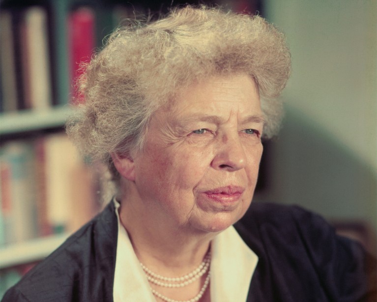 Close-up portrait of Eleanor Roosevelt sitting in front of a book shelf.