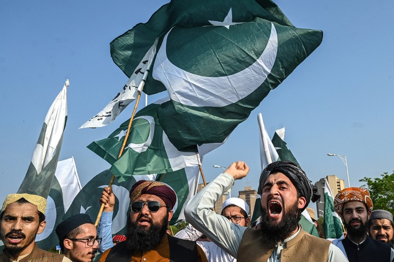 Un grupo de hombres grita consignas y ondea la bandera de Pakistán durante una protesta contra la India en Islamabad.