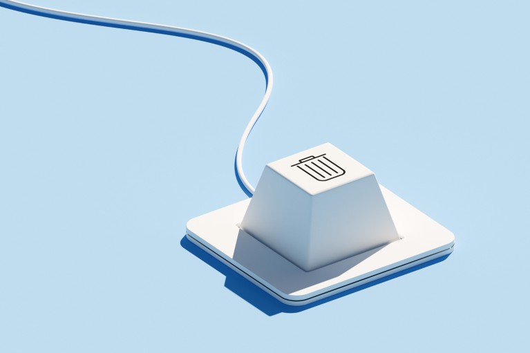A white computer keyboard with a single key featuring a trash icon on a blue background with a wire trailing out of frame