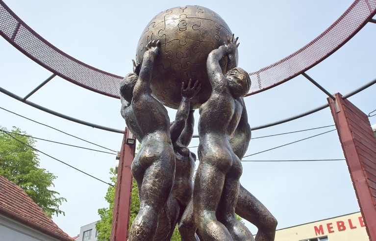 Statue of four bronze human figures holding a globe representing the Wikipedia logo.