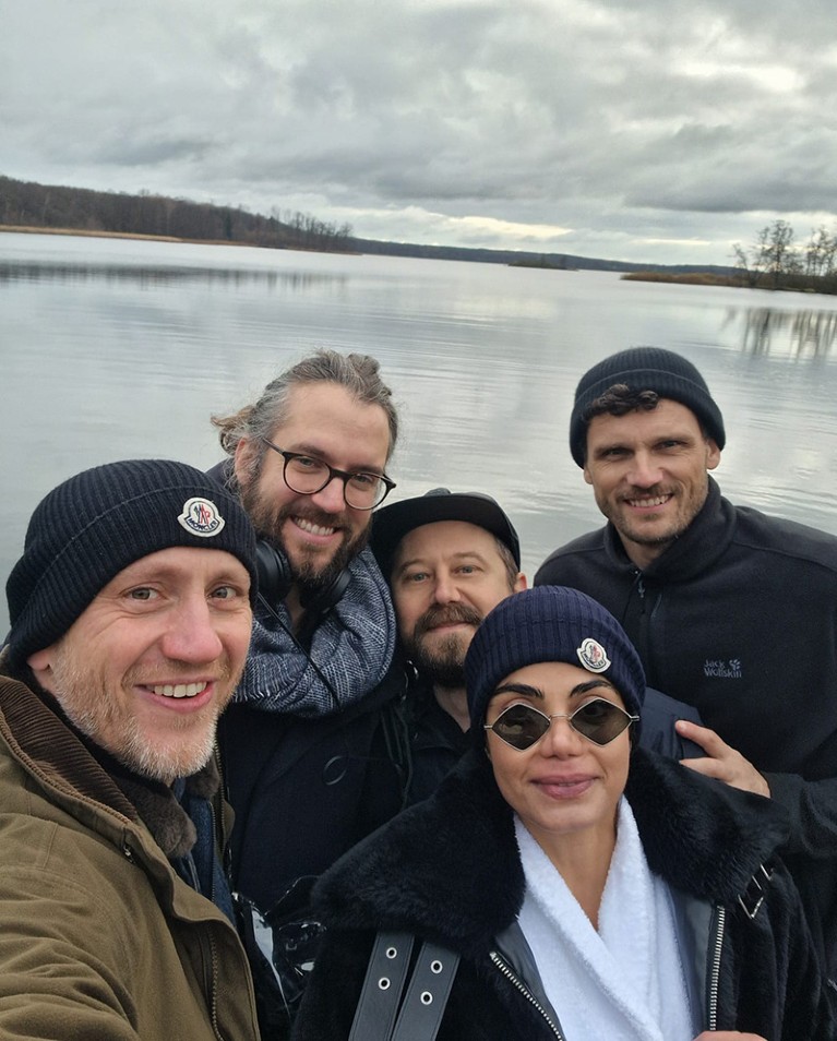 Five people stand in front of a lake.