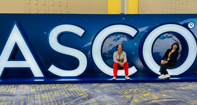 Еилеен Фауцхер и члан тима Брасс Тацк Келсеи Линцх седе на АСЦО знаку на састанку Америчког друштва за клиничку онкологију