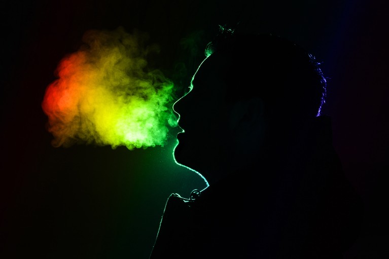 Coloured outline of a man exhaling warm breath on a black background with his head in silhouette.