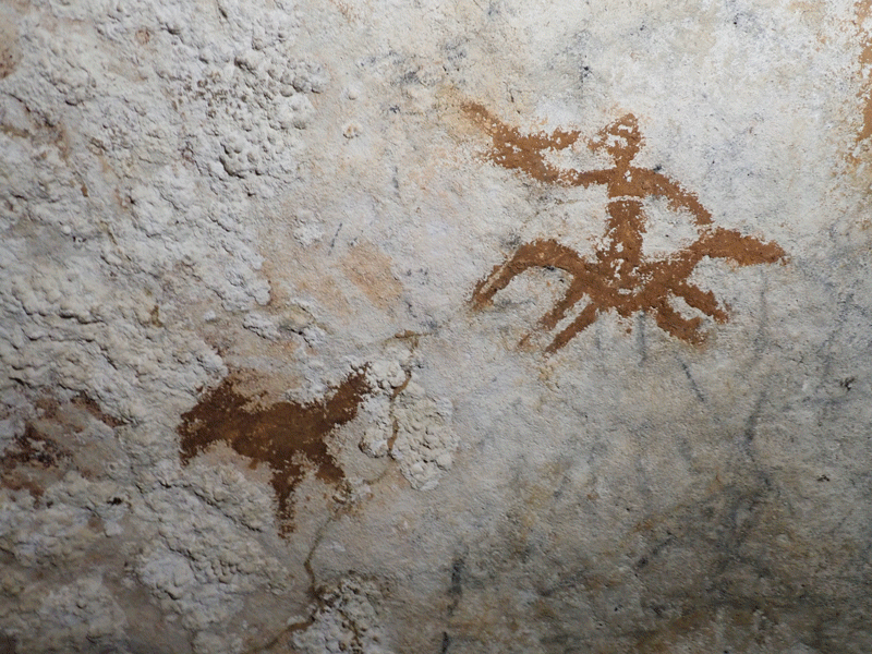 An animated GIF showing an ancient cave painting with the faint outline of a human hand, and enhanced versions of the same image to highlight the hand