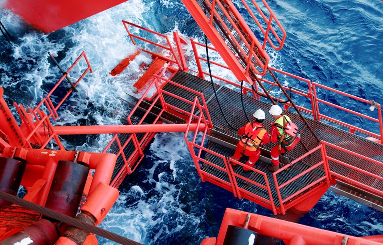 Два радника на низу црвених портала изнад мора.