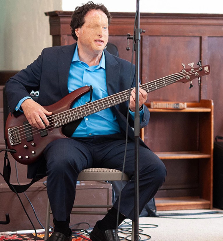 Josh Miele sat playing the bass guitar.