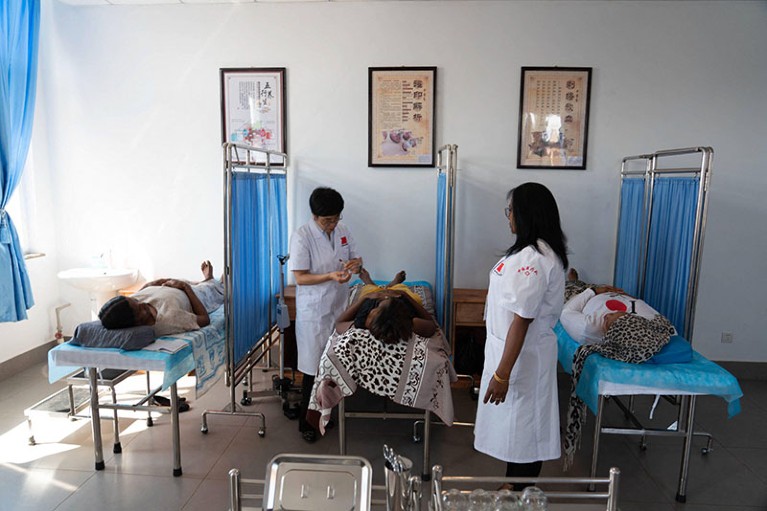 A Chinese doctor conducting acupuncture therapy for African patient in Chinese Medicine centre, in Madagascar
