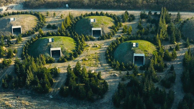 Поглед из ваздуха на неколико малих травнатих брежуљака у облику куполе, свако окружено дрвећем, и свако са правоугаоним улазом.