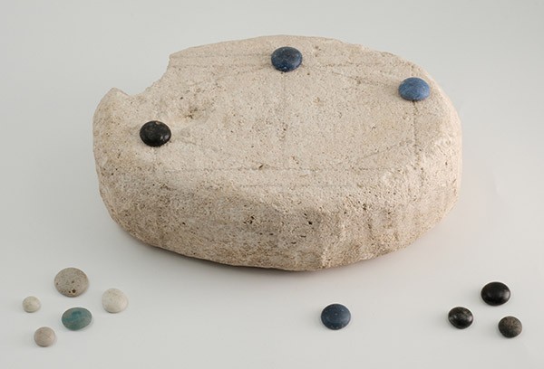 Камен за игру позирао је са типичним римским комадима игре.