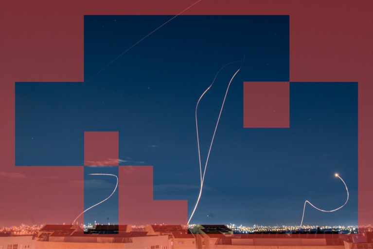 Streaks of light show the path of missiles above a city at night.