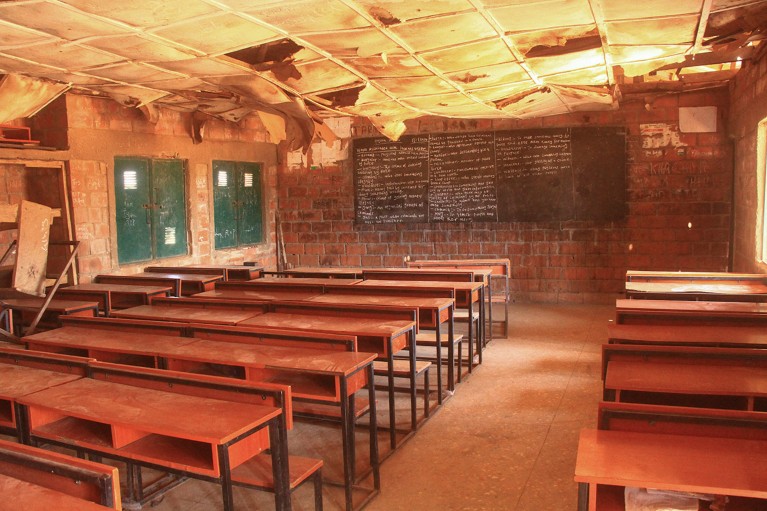 A view of rows of desks in an empty classroom at Kuriga school.