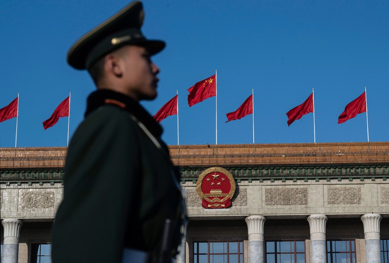 A uniformed member of the People's Armed Police stand at attention outside the Great Hall of the People in Beijing, China.