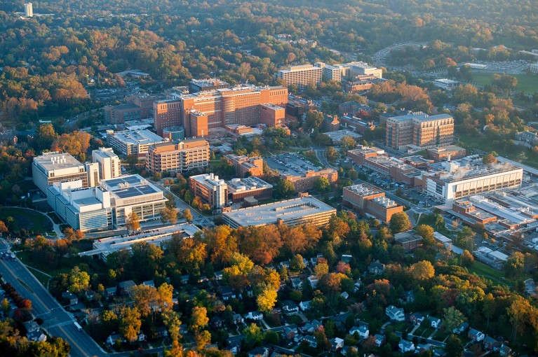 Aerial view of the U.S. National Institutes of Health campus buildings surround by towns.