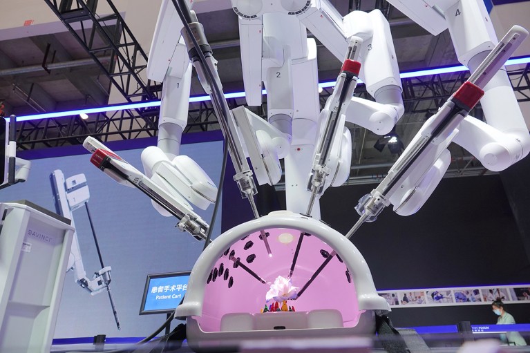 A mutli-limbed Da Vinci surgical robot on display during a demonstration of its capabilities.