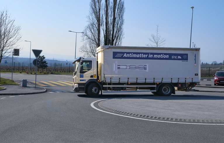 A CERN truck drives down a road as it transports a trap filled with antiprotons.