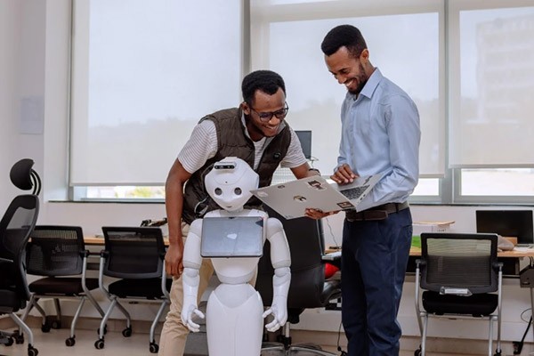 Birhanu Shimelis Girma and Joel Adebayo Oluwatooni work on the programming of Pepper.