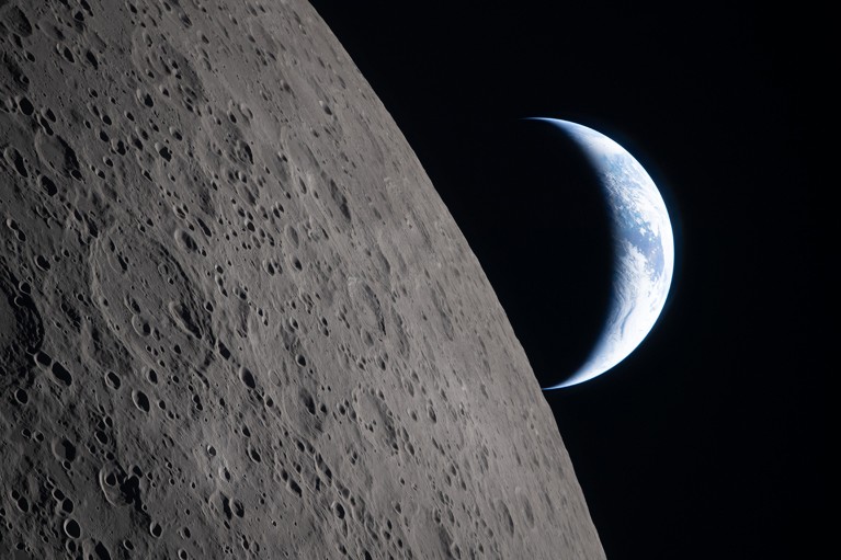 The Moon looms large in the foreground with the crescent of Earth in the background.