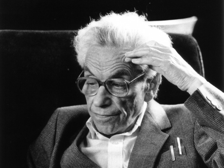 Black and white photo of Paul Erdős with his hand to his forehead thinking.