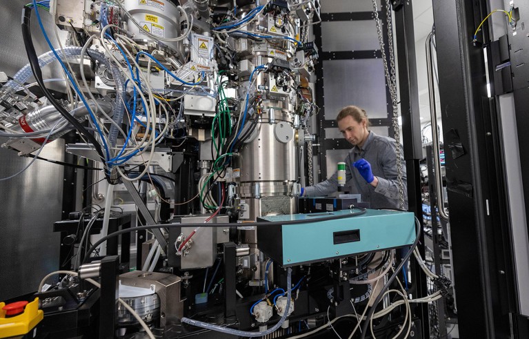 Biohub engineer Pavel Olshin makes adjustments to the laser phase plate cavity inside a cryo-electron microscope.
