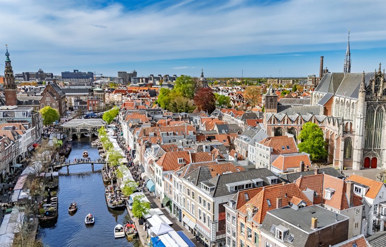 Aerial photograph of Leiden, featuring canals, historic houses and prominent churches.