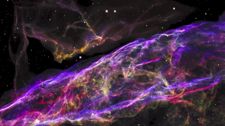 Detailed view of a small section of an expanding supernova remnant, in purple, pink and yellow.