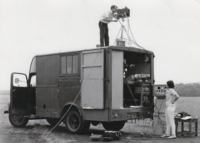 Black and white archive photo from the 1970s, showing two members of the RAE infrared group operating the trials vehicle in the field, 1970s.