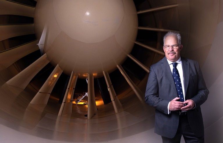 Portrait of David Dunford with an aircraft turbine behind him.