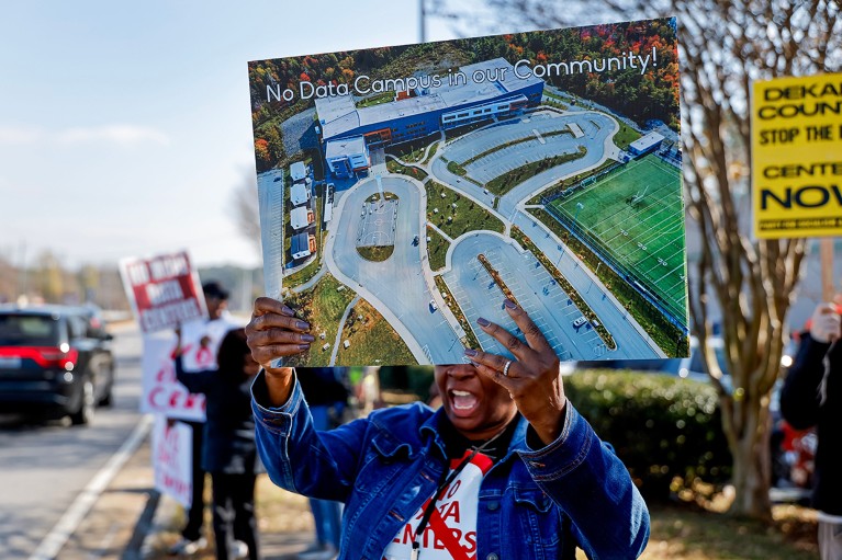 Demonstrators hold signs during a protest against a planned data centre in their area.