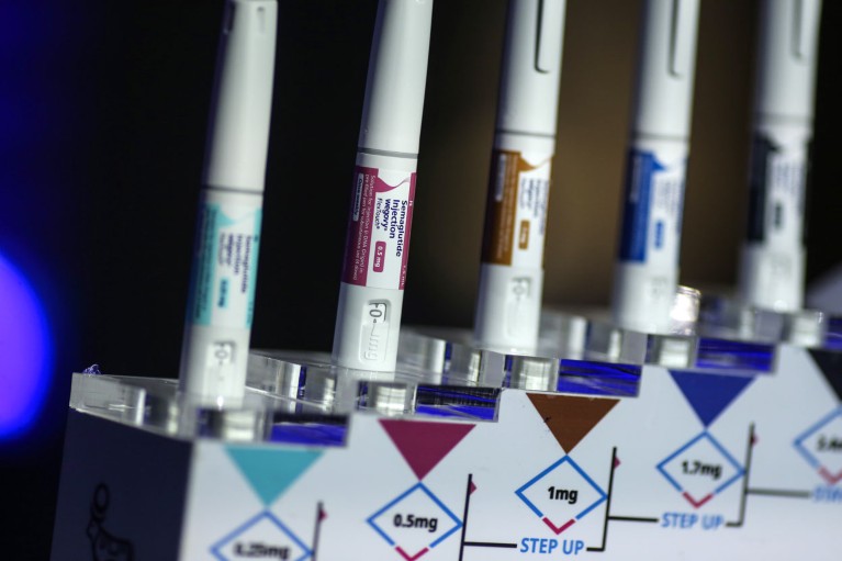 A row of injectable Wegovy weight-loss pens displayed on stands, with colour-coded dosage labels