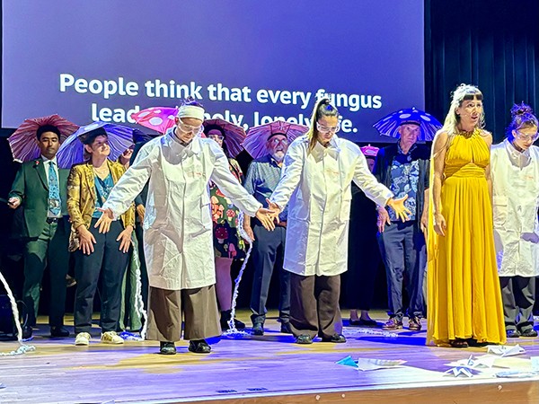 Theatrical stage performance at the Ig Nobel Prize ceremony in Zurich. In the background is a Nobel laureate wearing an umbrella.