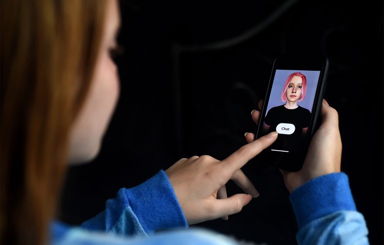 A person in blue clothing using a smartphone displaying a female avatar and ‘chat’ button.