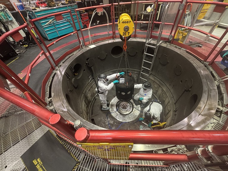 Technicians prepare the target holding samples at the centre of the Z machine, preparing the device to fire.